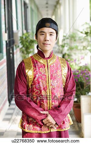 Portrait of a mid adult man in traditional clothing standing in a corridor View Large Photo Image Stock Image - Portrait of a mid adult man in traditional clothing standing in a corridor. Fotosearch