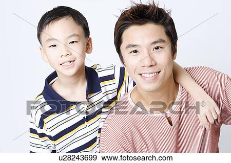 Stock Photo - Portrait of a mid adult man smiling with his son. Fotosearch