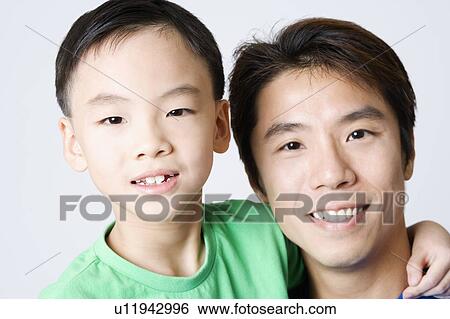Stock Photograph - Portrait of a mid adult man smiling with his son. Fotosearch