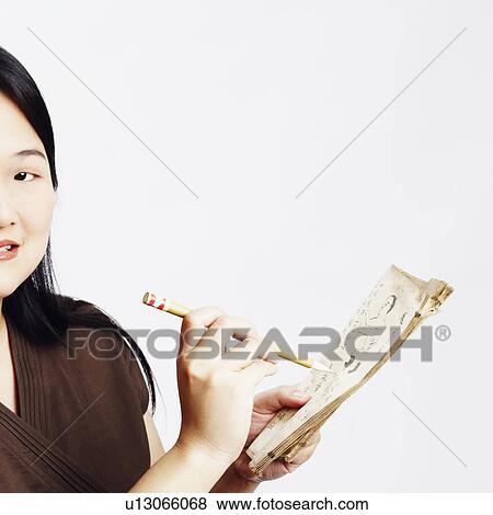 Portrait of a mid adult woman holding a pencil with a book and smiling View Large Photo Image Stock Photo - Portrait of a mid adult woman holding a pencil with a book and smiling. Fotosearch
