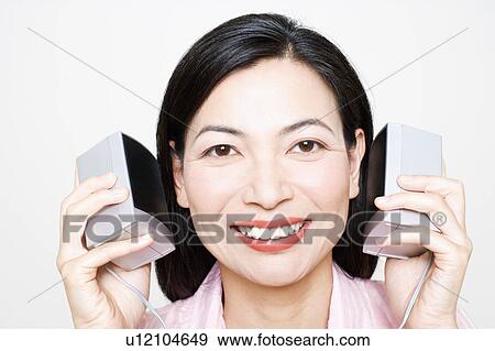 Portrait of a mid adult woman listening to music and holding speakers View Large Photo Image Stock Photo - Portrait of a mid adult woman listening to music and holding speakers. Fotosearch