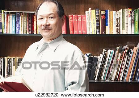 Stock Image - Portrait of a senior man holding a book. Fotosearch