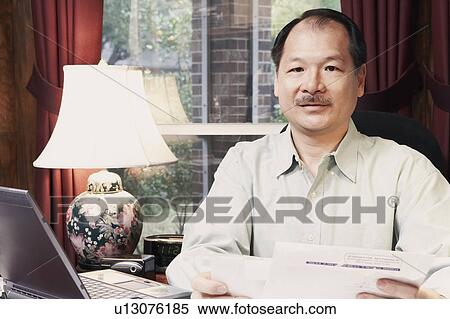 Stock Photography - Portrait of a senior man holding a letter. Fotosearch