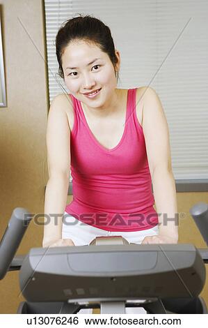 Portrait of a teenage girl exercising on an exercise bike View Large Photo Image Stock Photograph - Portrait of a teenage girl exercising on an exercise bike. Fotosearch