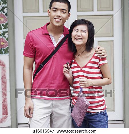 Stock Photo - Portrait of a young couple standing on a porch. Fotosearch