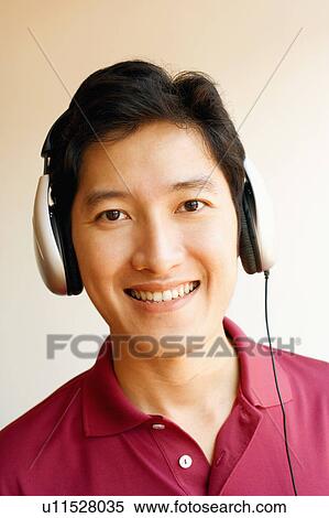 Portrait of a young man wearing headphones and listening to music View Large Photo Image Stock Photography - Portrait of a young man wearing headphones and listening to music. Fotosearch