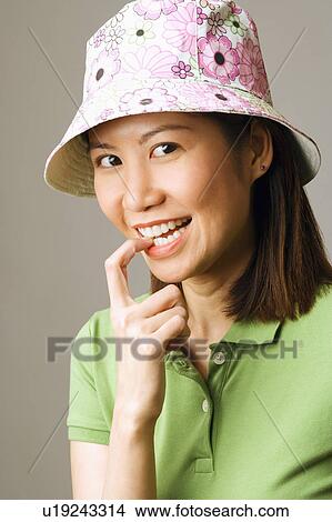 Picture - Portrait of a young woman biting her finger. Fotosearch