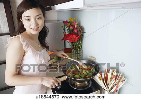 Portrait of a young woman cooking View Large Photo Image Stock Image - Portrait of a young woman cooking. Fotosearch