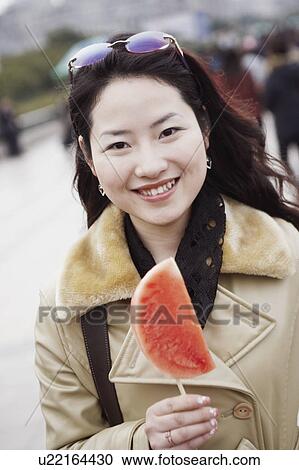 Portrait of a young woman holding a slice of watermelon View Large Photo Image Stock Image - Portrait of a young woman holding a slice of watermelon. Fotosearch