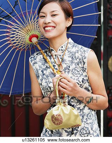 Portrait of a young woman holding a parasol View Large Photo Image Stock Photography - Portrait of a young woman holding a parasol. Fotosearch