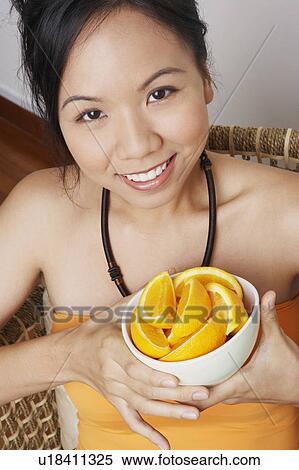 Portrait of a young woman holding a bowl and smiling View Large Photo Image Stock Photography - Portrait of a young woman holding a bowl and smiling. Fotosearch