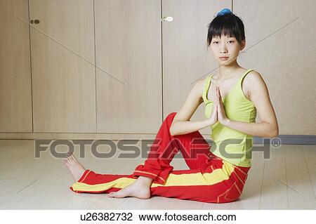 Stock Image - Portrait of a young woman in a yoga position. Fotosearch