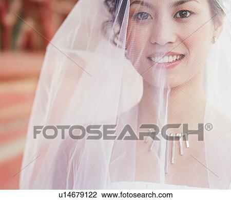 Stock Image - Portrait of a young woman in the wedding dress. Fotosearch