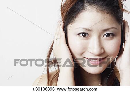 Portrait of a young woman listening to music View Large Photo Image Stock Image - Portrait of a young woman listening to music. Fotosearch