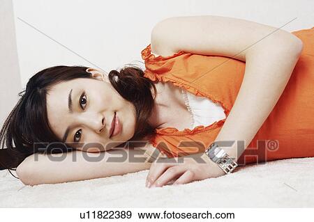 Portrait of a young woman lying down View Large Photo Image Stock Photo - Portrait of a young woman lying down. Fotosearch