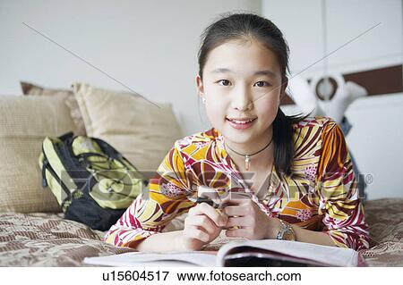 Portrait of a young woman lying on the bed View Large Photo Image Stock Photo - Portrait of a young woman lying on the bed. Fotosearch