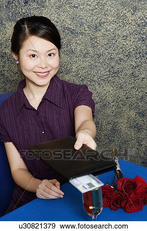 Portrait of a young woman paying with a credit card in restaurant View Large Photo Image Stock Photo - Portrait of a young woman paying with a credit card in restaurant. Fotosearch