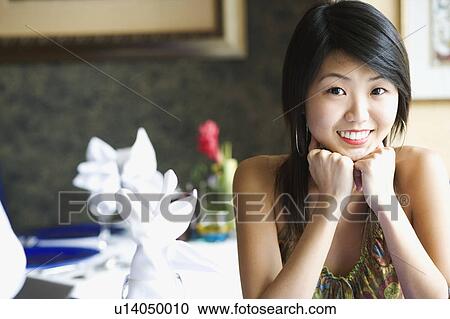 Portrait of a young woman smiling in a restaurant View Large Photo Image Stock Image - Portrait of a young woman smiling in a restaurant. Fotosearch