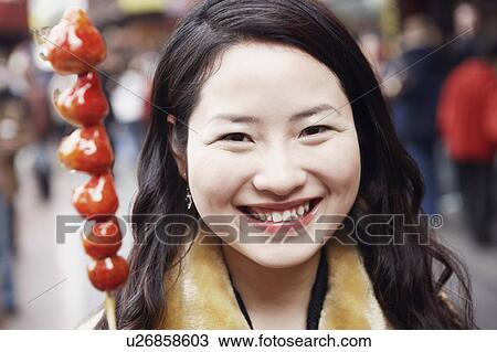 Portrait of a young woman smiling behind a stick of avocados View Large Photo Image Stock Image - Portrait of a young woman smiling behind a stick of avocados. Fotosearch