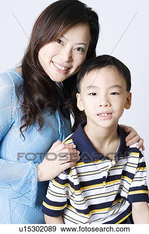 Portrait of a young woman smiling with her son View Large Photo Image Stock Photo - Portrait of a young woman smiling with her son. Fotosearch