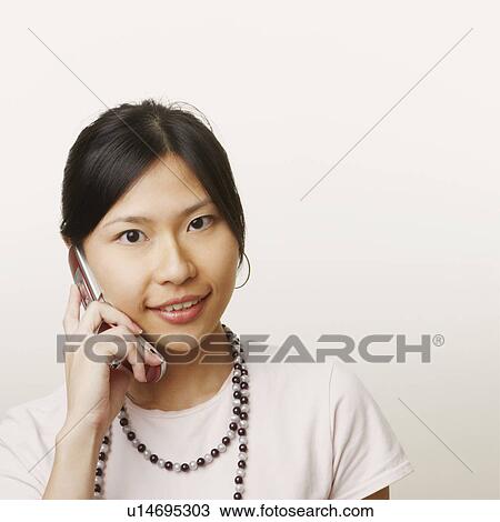 Portrait of a young woman talking on a mobile phone View Large Photo Image Stock Image - Portrait of a young woman talking on a mobile phone. Fotosearch