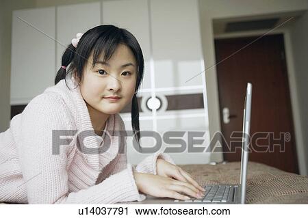 Portrait of a young woman using a laptop View Large Photo Image Stock Image - Portrait of a young woman using a laptop. Fotosearch