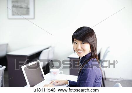 Portrait of a young woman using a laptop View Large Photo Image Stock Image - Portrait of a young woman using a laptop. Fotosearch