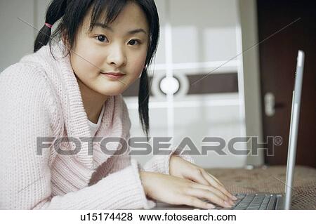 Stock Photo - Portrait of a young woman using a laptop. Fotosearch