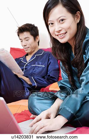 Portrait of a young woman using a laptop and mid adult man reading a newspaper View Large Photo Image Stock Image - Portrait of a young woman using a laptop and mid adult man reading a newspaper. Fotosearch