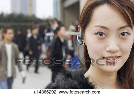 Portrait of a young woman wearing a hands free device View Large Photo Image Stock Image - Portrait of a young woman wearing a hands free device. Fotosearch