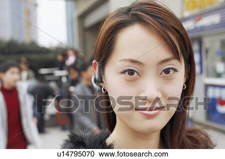 Portrait of a young woman wearing a hands free device View Large Photo Image Stock Image - Portrait of a young woman wearing a hands free device. Fotosearch