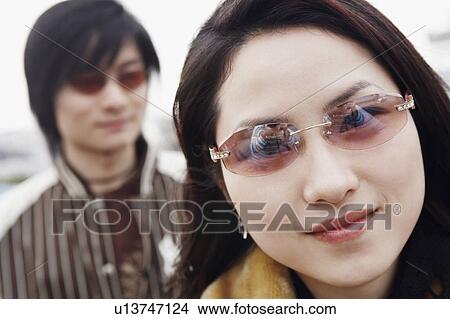 Picture - Portrait of a young woman wearing sunglasses. Fotosearch