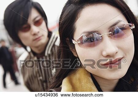 Portrait of a young woman wearing sunglasses View Large Photo Image Stock Photograph - Portrait of a young woman wearing sunglasses. Fotosearch