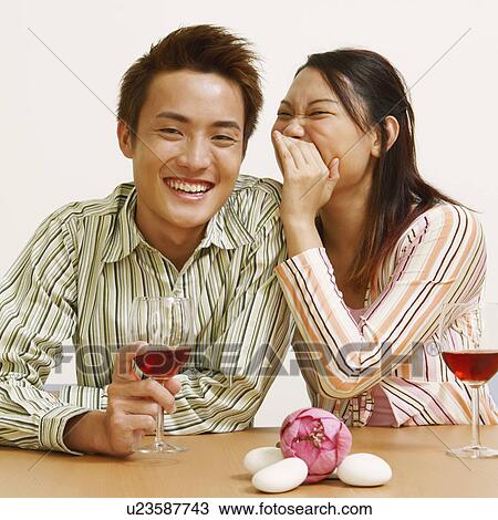 Portrait of a young woman whispering into a young man's ear View Large Photo Image Stock Image - Portrait of a young woman whispering into a young man's ear. Fotosearch