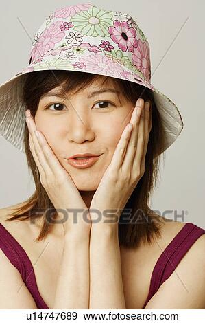 Portrait of a young woman with her hand on her cheeks View Large Photo Image Stock Photo - Portrait of a young woman with her hand on her cheeks. Fotosearch