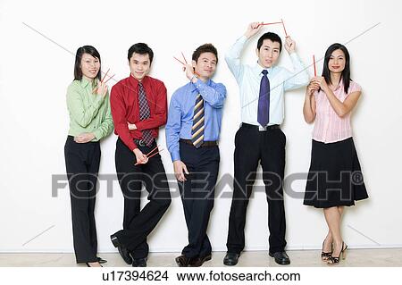 Picture - Portrait of five business executives holding chopsticks. Fotosearch