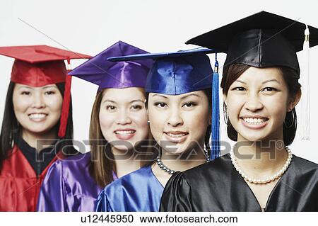 Stock Image - Portrait of four female graduates standing in a row. Fotosearch