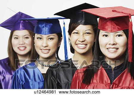 Stock Image - Portrait of four female graduates standing in a row. Fotosearch
