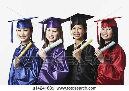 Stock Photography - Portrait of four female graduates standing in a row holding diplomas. Fotosearch