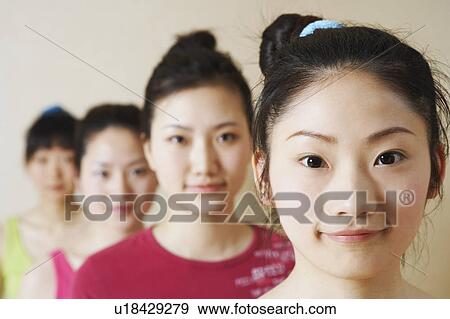 Stock Photo - Portrait of four young women in a row. Fotosearch