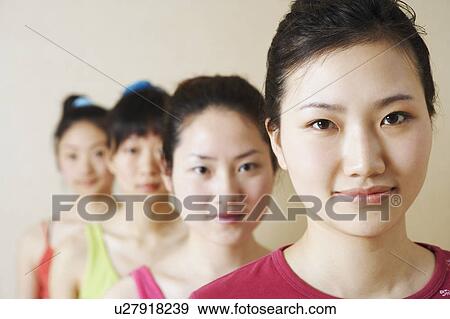 Stock Photo - Portrait of four young women in a row. Fotosearch