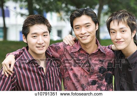 Stock Image - Portrait of three young men smiling. Fotosearch
