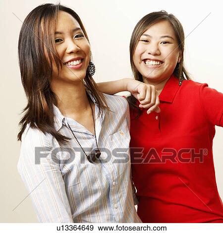 Stock Photo - Portrait of two young women looking cheerful. Fotosearch