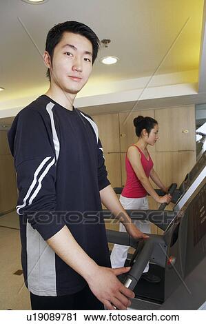 Side profile of a young man and a young woman exercising in a gym View Large Photo Image Stock Image - Side profile of a young man and a young woman exercising in a gym. Fotosearch