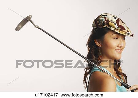 Side profile of a young woman holding a golf club and looking down View Large Photo Image Stock Photo - Side profile of a young woman holding a golf club and looking down. Fotosearch