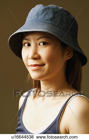 Side profile of a young woman wearing a hat View Large Photo Image Stock Photo - Side profile of a young woman wearing a hat. Fotosearch