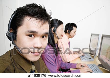 Stock Photograph - Three customer service representatives working on computers. Fotosearch