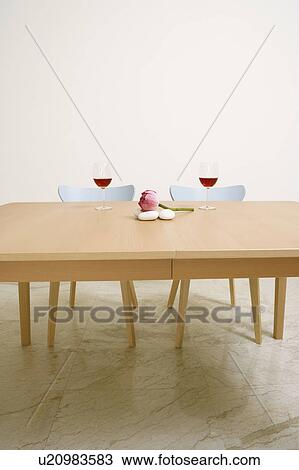 Stock Image - Two glasses of red wine with a lotus on the table. Fotosearch