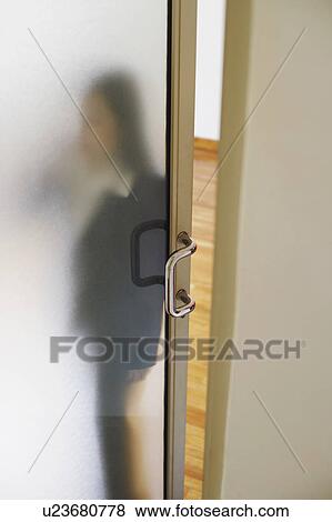 Stock Photo - Woman standing behind a door. Fotosearch