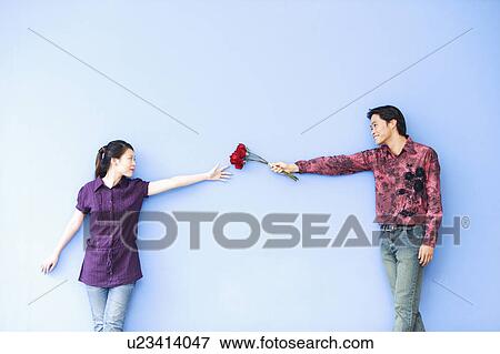 Stock Photo - Young man giving roses to a young woman. Fotosearch